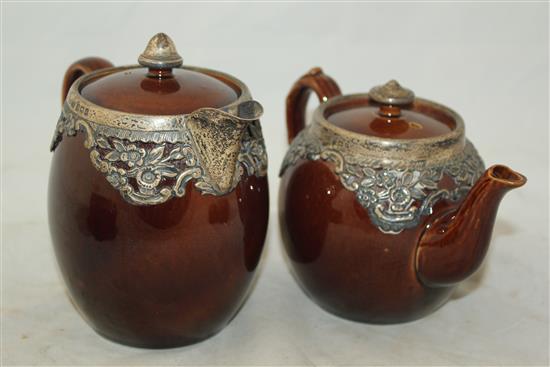 Wedgwood treacle glazed pottery silver mounted part tea set, c.1906, the hot water pot 13cm., one plate broken (13)(-)